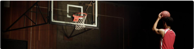 image of male student shooting a basketball into a basketball hoop.