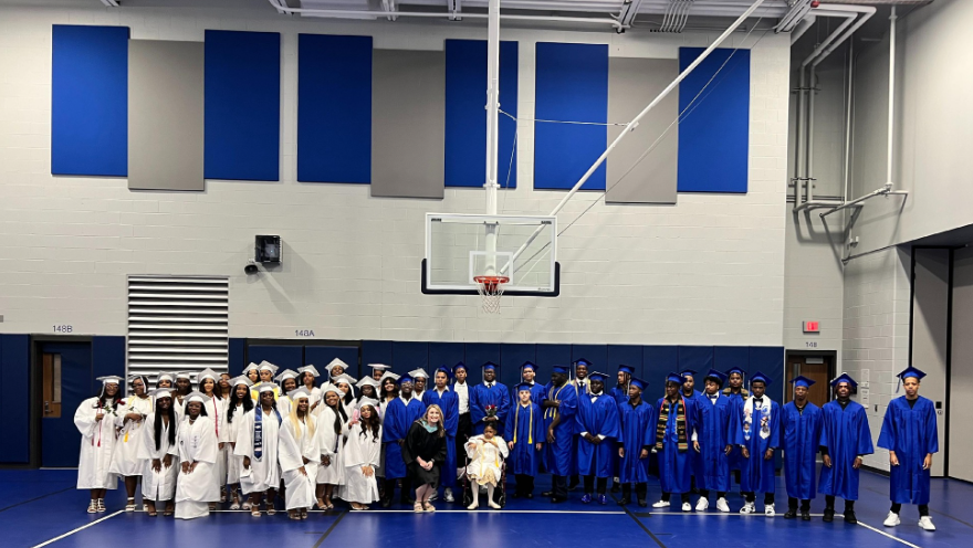 photo of the RHLS Class of 2023 blue and white cap and gowns male and female students blue and grey background